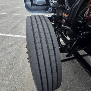 Front left dual rear tire of a Mack PI64T truck chassis showing tread and suspension components.