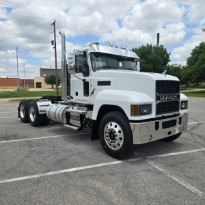 Mack PI64T truck in a parking lot showing front grille, cab, and dual rear axles with chrome bumper and exhaust stacks.
