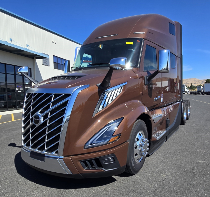 Volvo VNL64T860 sleeper cab truck in brown with chrome grille and polished wheels, side view showing front and cab extensions.