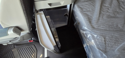 Volvo VNL64T860 truck interior showing open center console storage and passenger-side footwell with protective plastic cover.