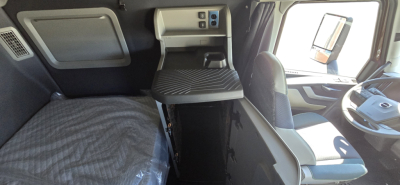 Volvo VNL64T860 sleeper cab interior showing driver's seat, bench bed, overhead control module, and dashboard.