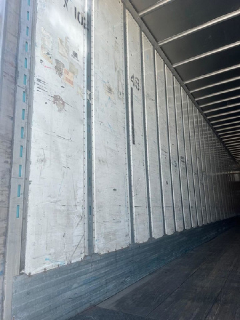 Trailer interior showing metal wall panels and wooden floor indicating cargo area of a used utility van/trailer.
