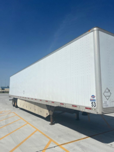  Trailer box showing side of a white utility trailer with DOT reflective tape, corner trim, and support legs.
