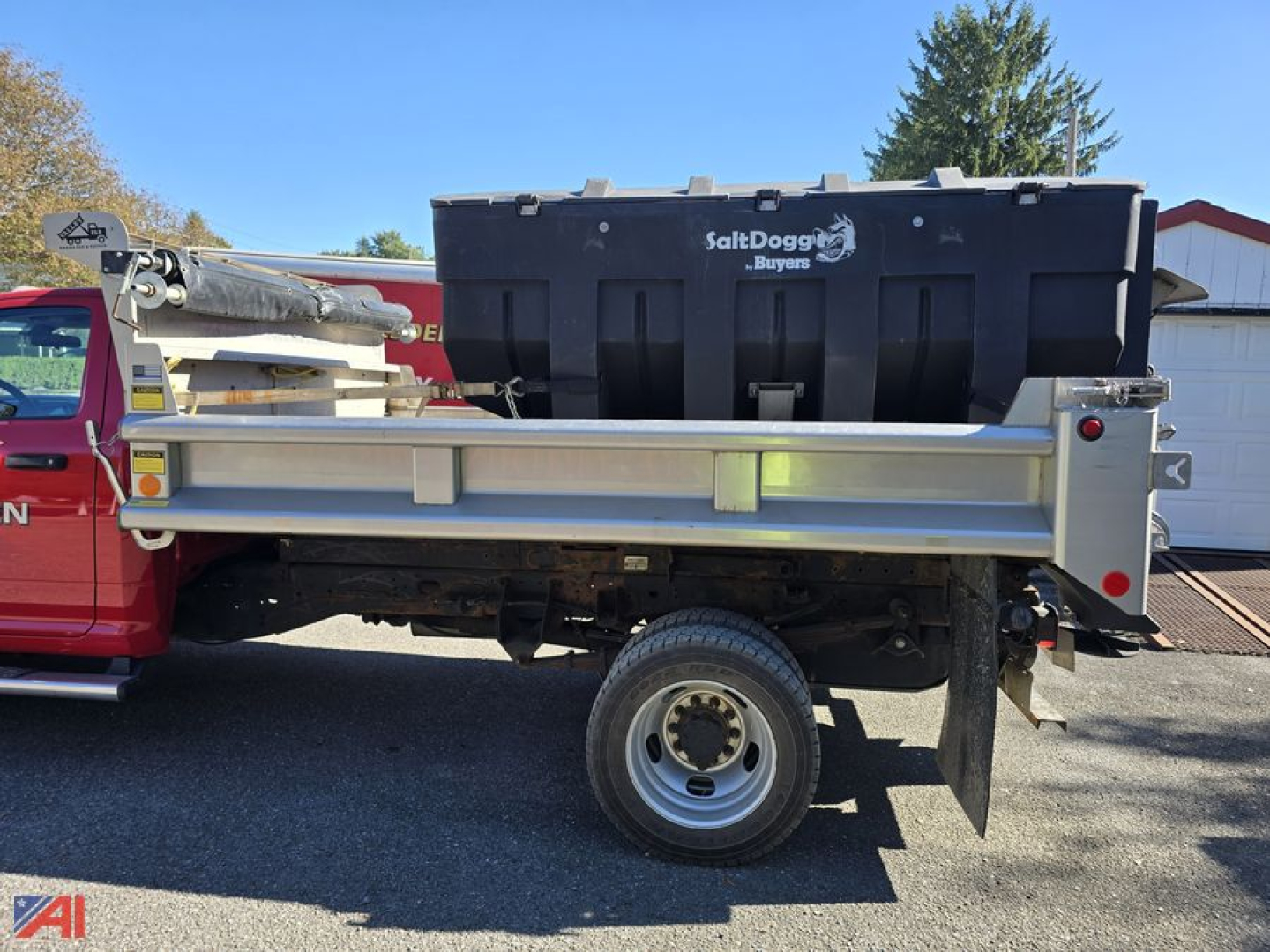 Ram 5500 dump truck with plow and sander, side view showing SaltDog Buoys storage box and hydraulic components.