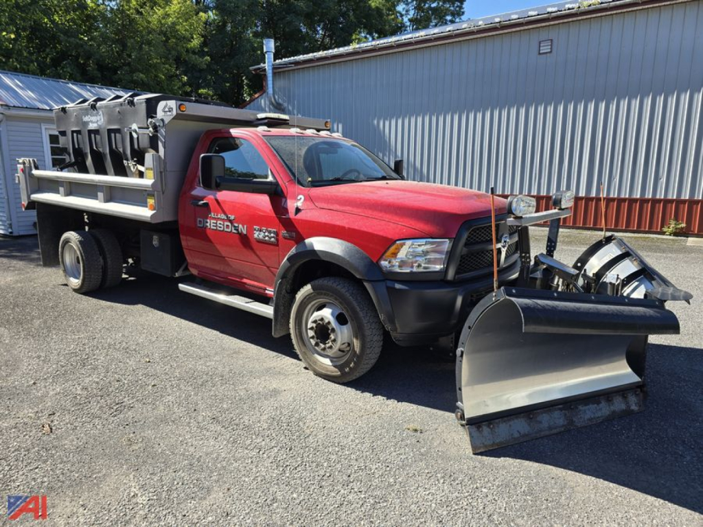 Ram 5500 dump truck with plow and sander, red cab, large front snow plow, utility bed with equipment boxes, serial sticker visible on door, used condition.