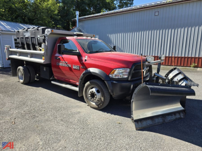 Ram 5500 dump truck with plow and sander, red cab, large front snow plow, utility bed with equipment boxes, serial sticker visible on door, used condition.
