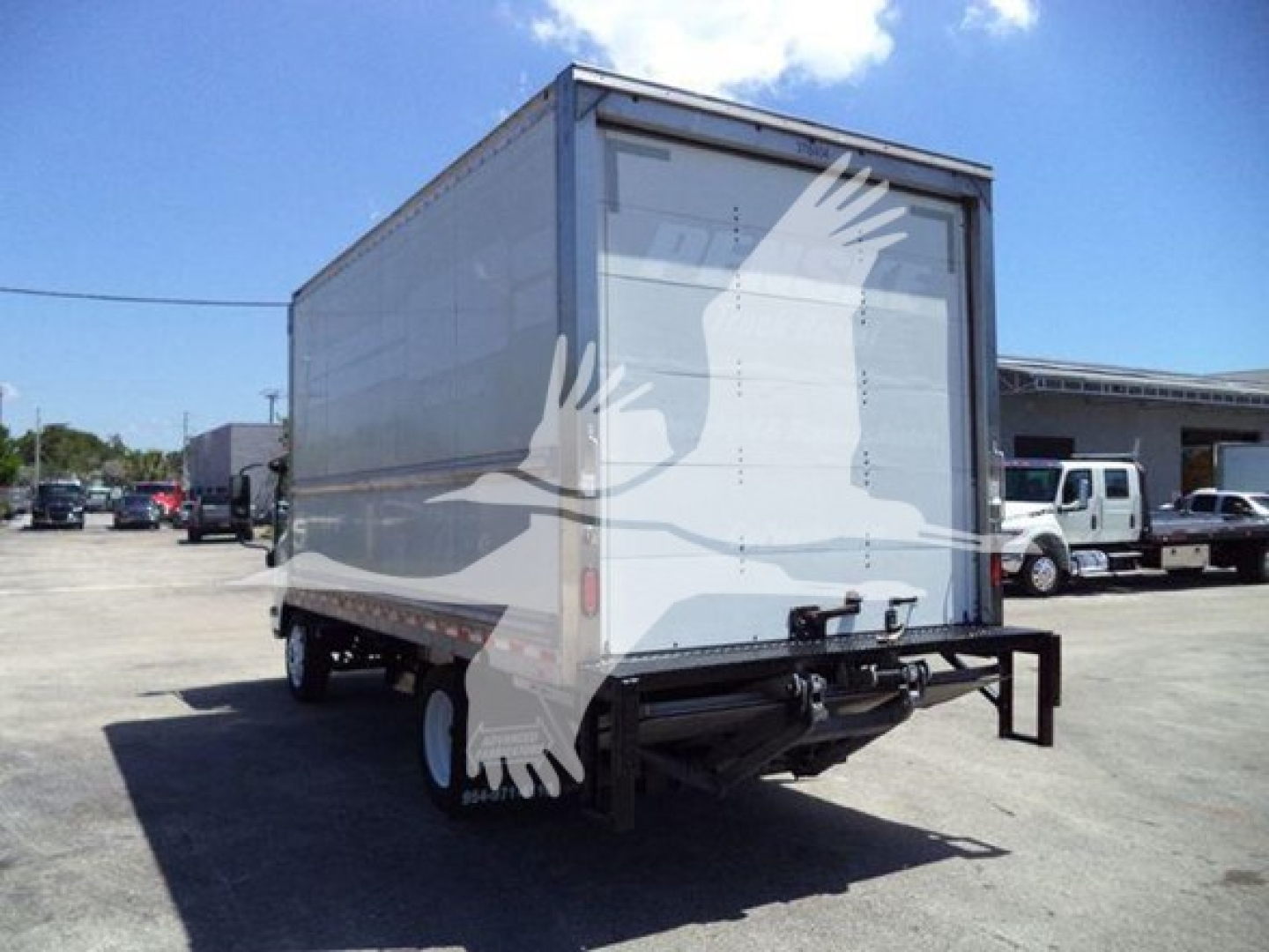 Isuzu NPR-HD box truck rear view showing cargo box and rear bumper, tail lights, and dual rear wheels.