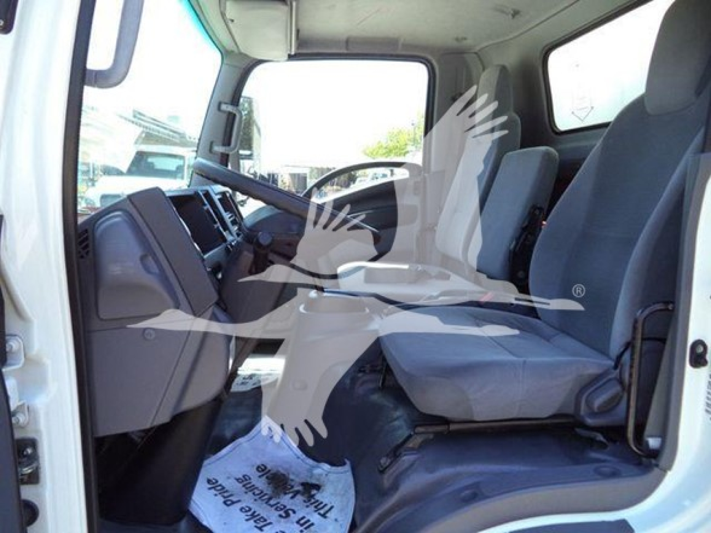 Isuzu NPR HD cab interior showing front seats and dashboard in right-hand drive? No, left-hand drive. Text not visible clearly. 