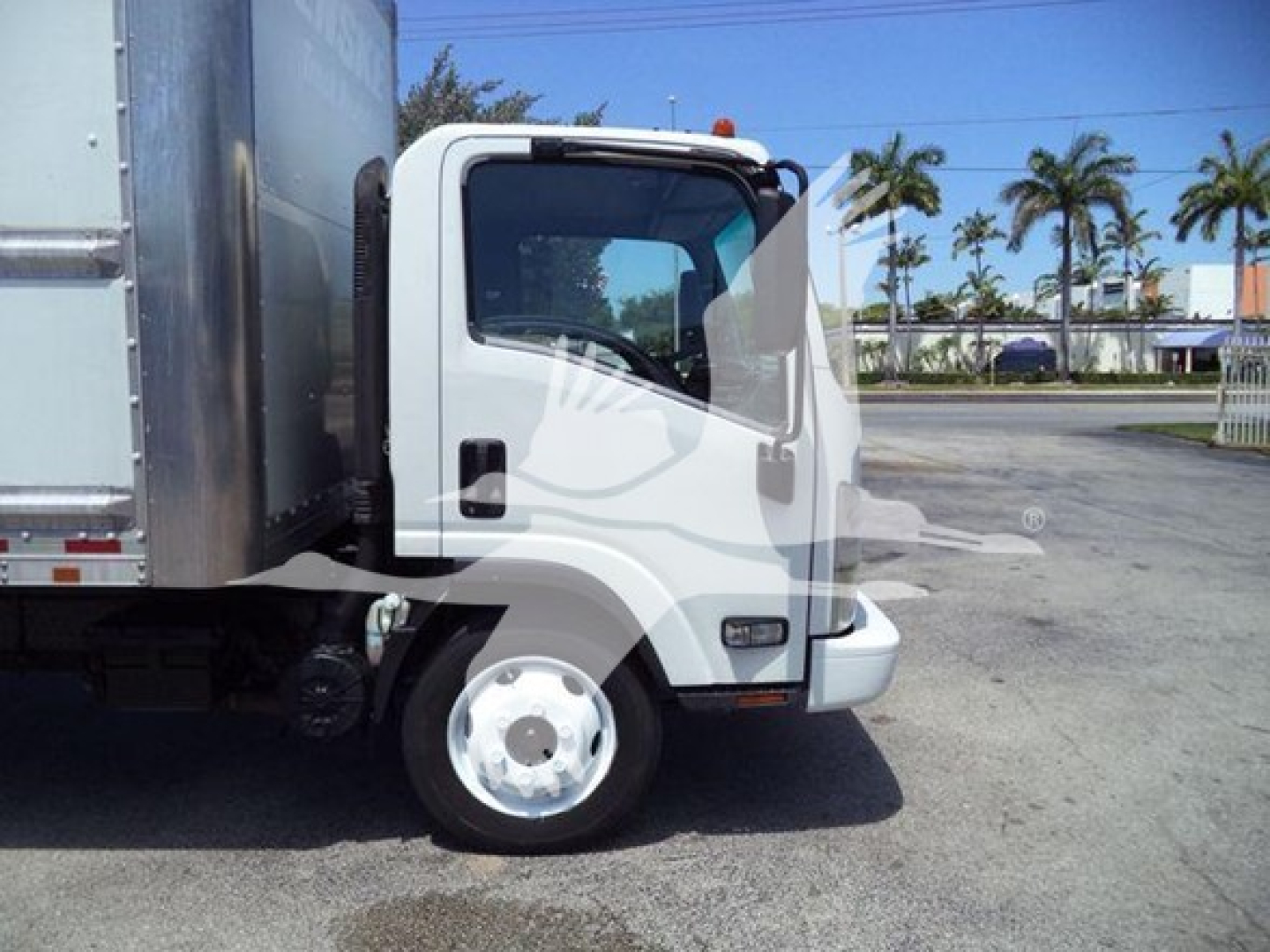 Isuzu NPR-HD truck cab side view showing front wheel, door, and part of box body.