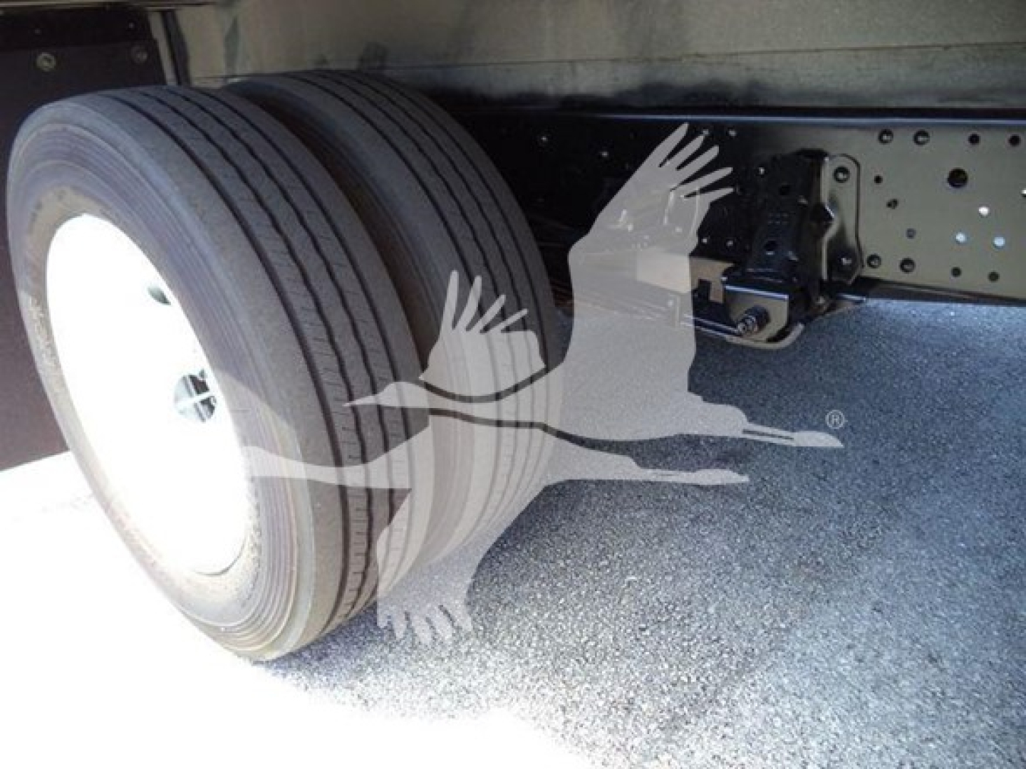 Isuzu NPR HD truck rear wheel and undercarriage with dual rear tires and chassis.