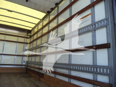 Truck box interior with metal side rails and a large graphic of an eagle on the wall. Light enters from the roof window.