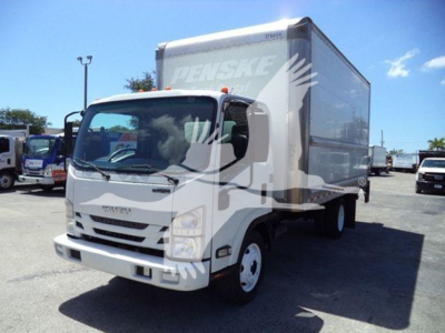 Isuzu NPR-HD box truck with a Penske cargo trailer, front-left view, white cab and box, daylight outdoor lot.
