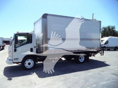 Isuzu NPR-HD box truck side view with cargo box and cab, street and other trucks in background.
