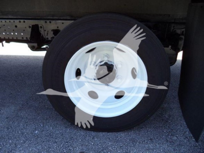 Isuzu NPR HD truck wheel and undercarriage showing a white steel wheel with black tire.