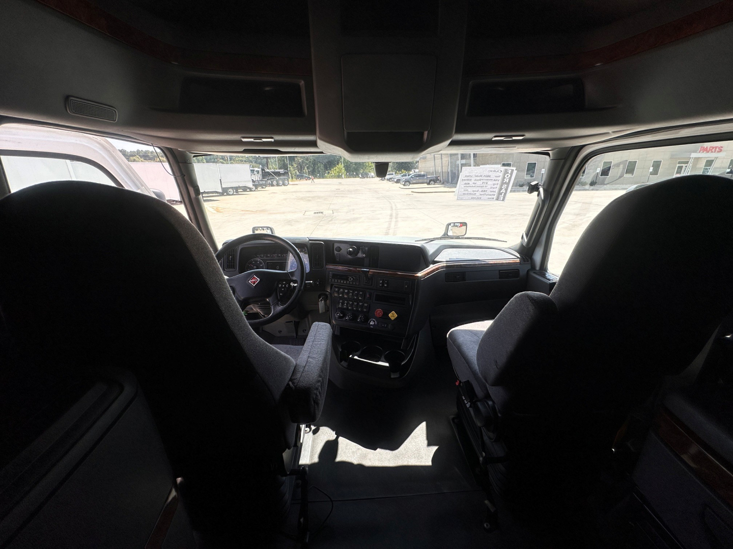 Cab interior of a 2021 International LT625 truck showing dashboard controls and steering wheel, with two front seats and windshield, no legible labels visible.