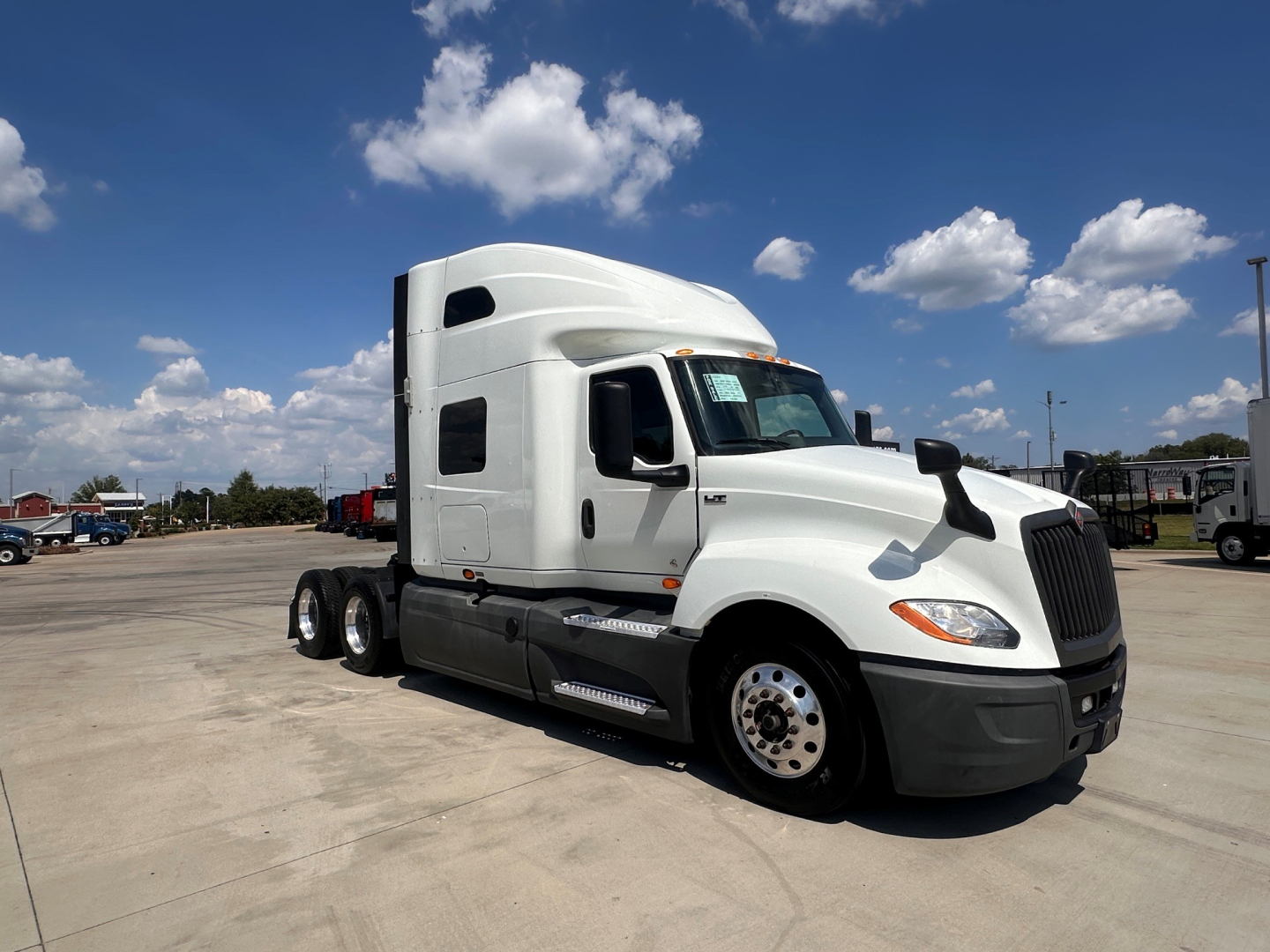 International LT625 truck in a parking lot showing exterior cab and sleeper with white paint and chrome wheels.