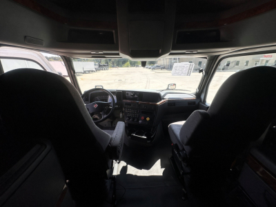 Cab interior of a 2021 International LT625 truck showing dashboard controls and steering wheel, with two front seats and windshield, no legible labels visible.