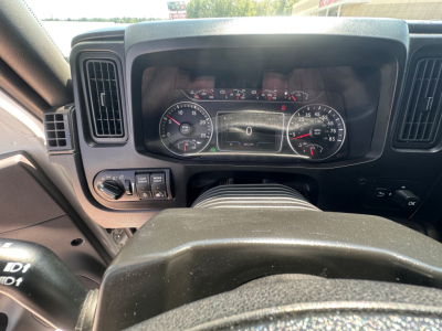 Dashboard of 2021 International LT625 showing instrument cluster with speedometer, tachometer, and digital display in center; steering wheel and control stalks visible.