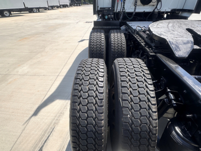 Dual rear axles and fifth wheel visible on a used 2021 International LT625 truck showing heavy-duty tires and chassis.