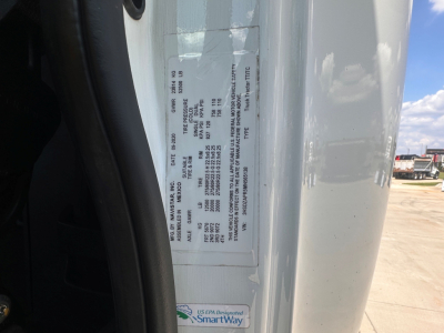 Label on truck door jamb with vehicle VIN and specifications; sticker with small text, part of frame showing a white label and some black printed details.