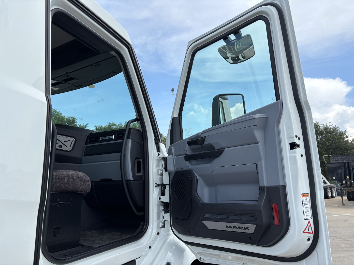 Mack AN64 dump truck cabin interior with open door showing gray and black door panel and steering wheel.