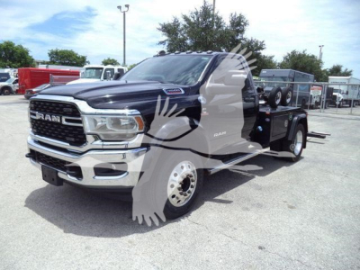 Ram 4500 heavy-duty tow truck with black exterior in a dealership lot, front grille, RAM emblem, winch bed in rear, VIN badge not visible