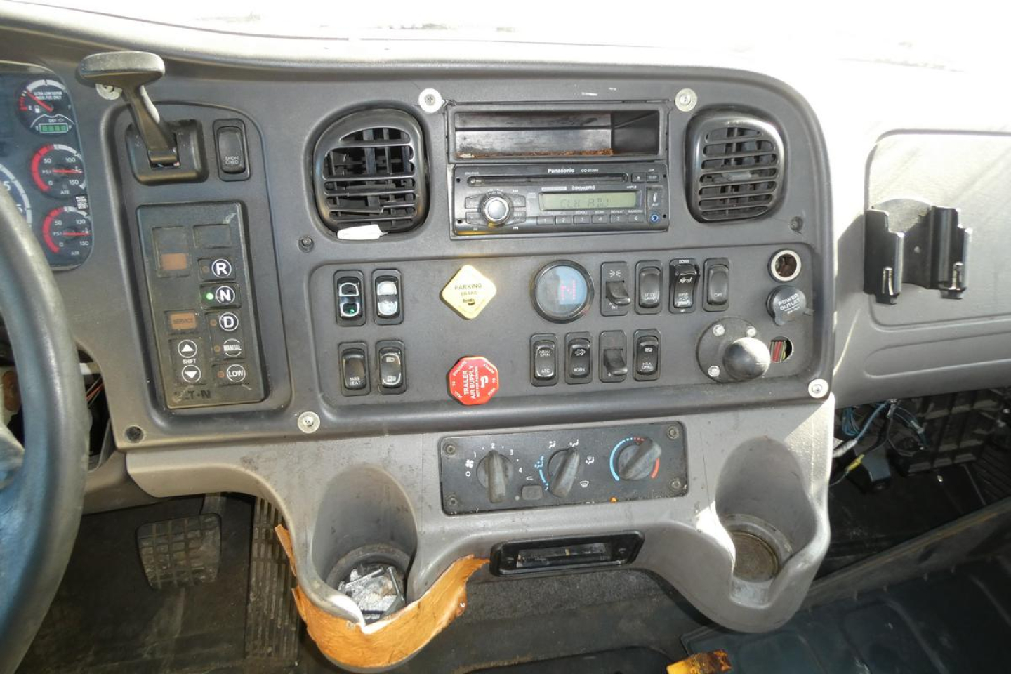 Dashboard of a Freightliner M2 112 cab with controls, gauges, and climate controls visible.