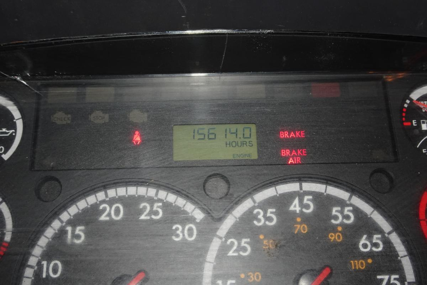Dashboard view of a 2015 Freightliner M2 112 showing gauges and an engine hours readout of 1561.40 hours with brake warning lights visible.