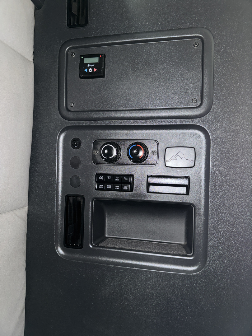 Cab interior panel of a 2019 Freightliner Cascadia showing a rectangular access panel, climate controls, and storage pocket in the dash area.
