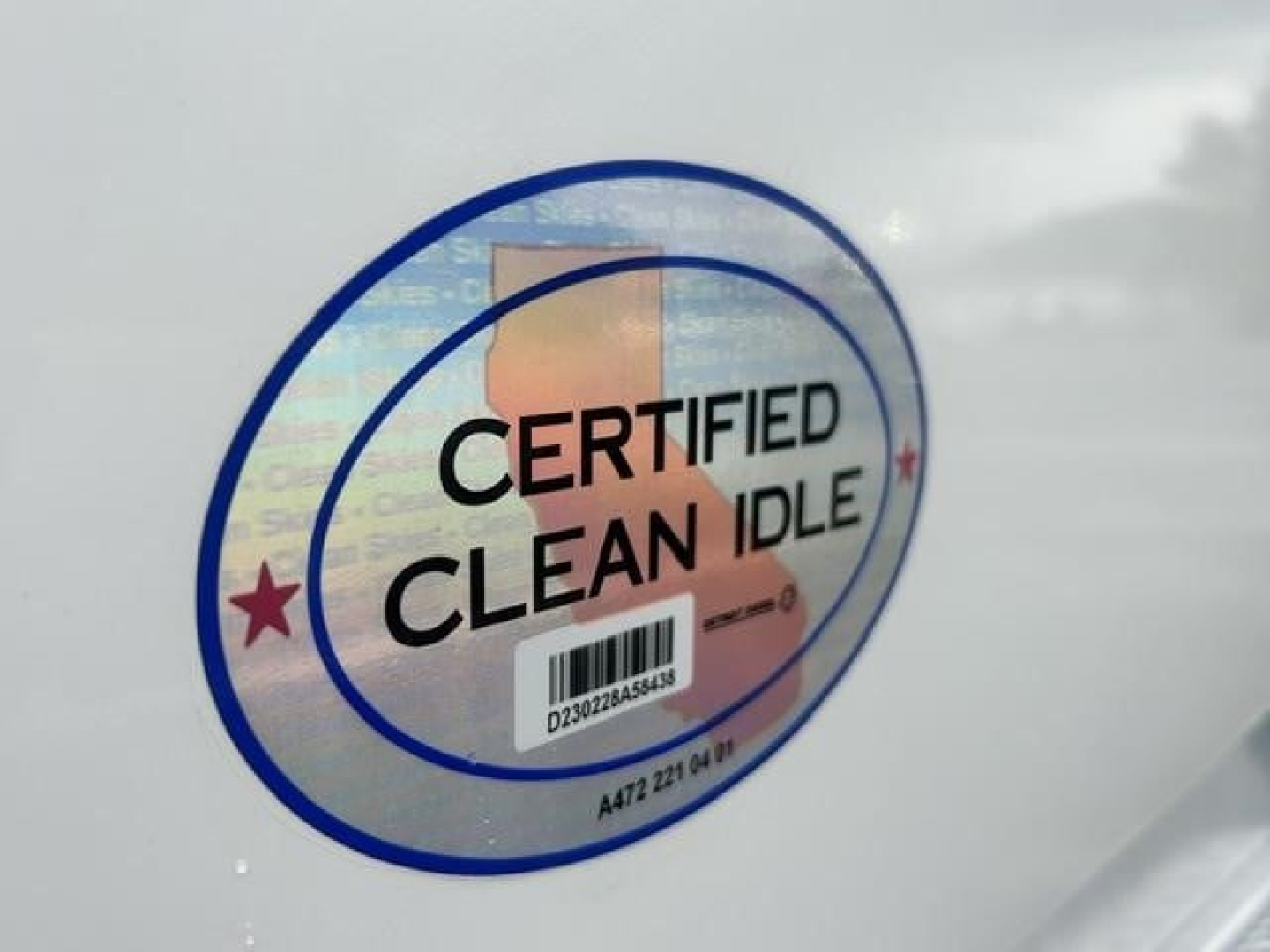 Sticker on vehicle showing 'CERTIFIED CLEAN IDLE' with a barcode and text around circle.