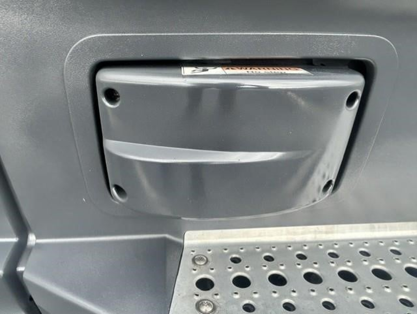Freightliner Cascadia 126 truck exterior showing step and storage panel under the cab with metal tread plate.