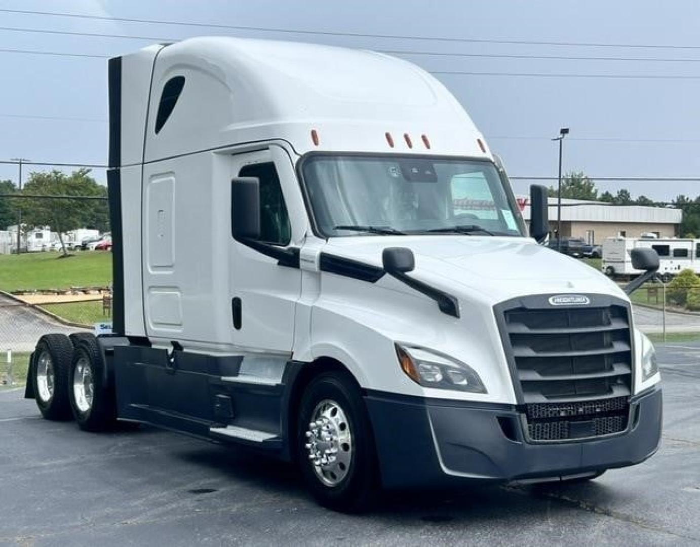 Freightliner Cascadia 126 conventional sleeper truck in view showing sidelined cab and dual rear axles.