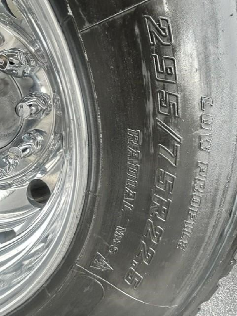 Tire sidewall showing 295/75R22.5 and Ultra-High Pressure tire details on a Freightliner Cascadia wheel.
