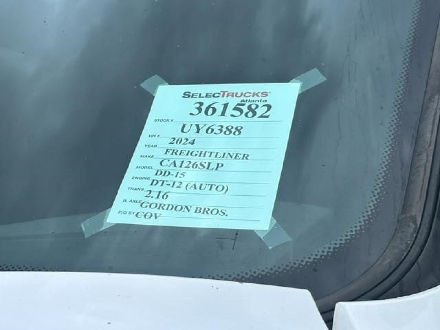 Window sticker on Freightliner Cascadia showing stock number 361582, VIN 3AKJHHDR6RSUY6388, model DT-12, 2.16 TD-? engine details and Gordon Bros. dealer information.