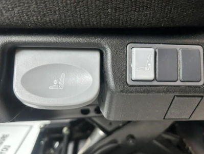 Cabin controls and seat adjustment lever in a Freightliner Cascadia 126 interior showing a circular knob and a row of buttons.
