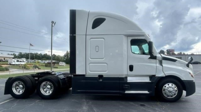 Freightliner Cascadia 126 tractor in side profile showing sleeper cab, six wheels, chrome wheels, and aerodynamic side panels.