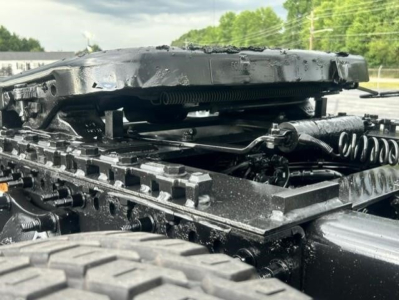 Freightliner Cascadia chassis showing suspension and frame components with hoses and coils visible under a damaged cab area.