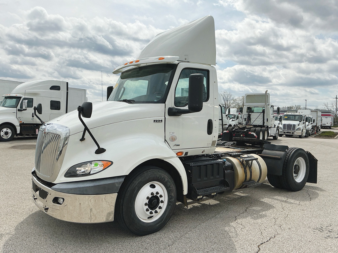 Truck in a dealership lot showing 2019 International RH613 conventional daycab with hood ornament, fuel tanks, and chassis, no visible text on the cab except standard International styling.