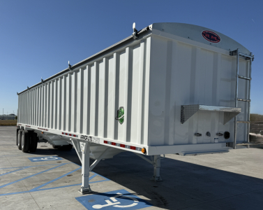 Armor Lite 40' steel grain hopper trailer in unused condition showing front-right side and hitch, with VIN plate and spare wheel mounting.