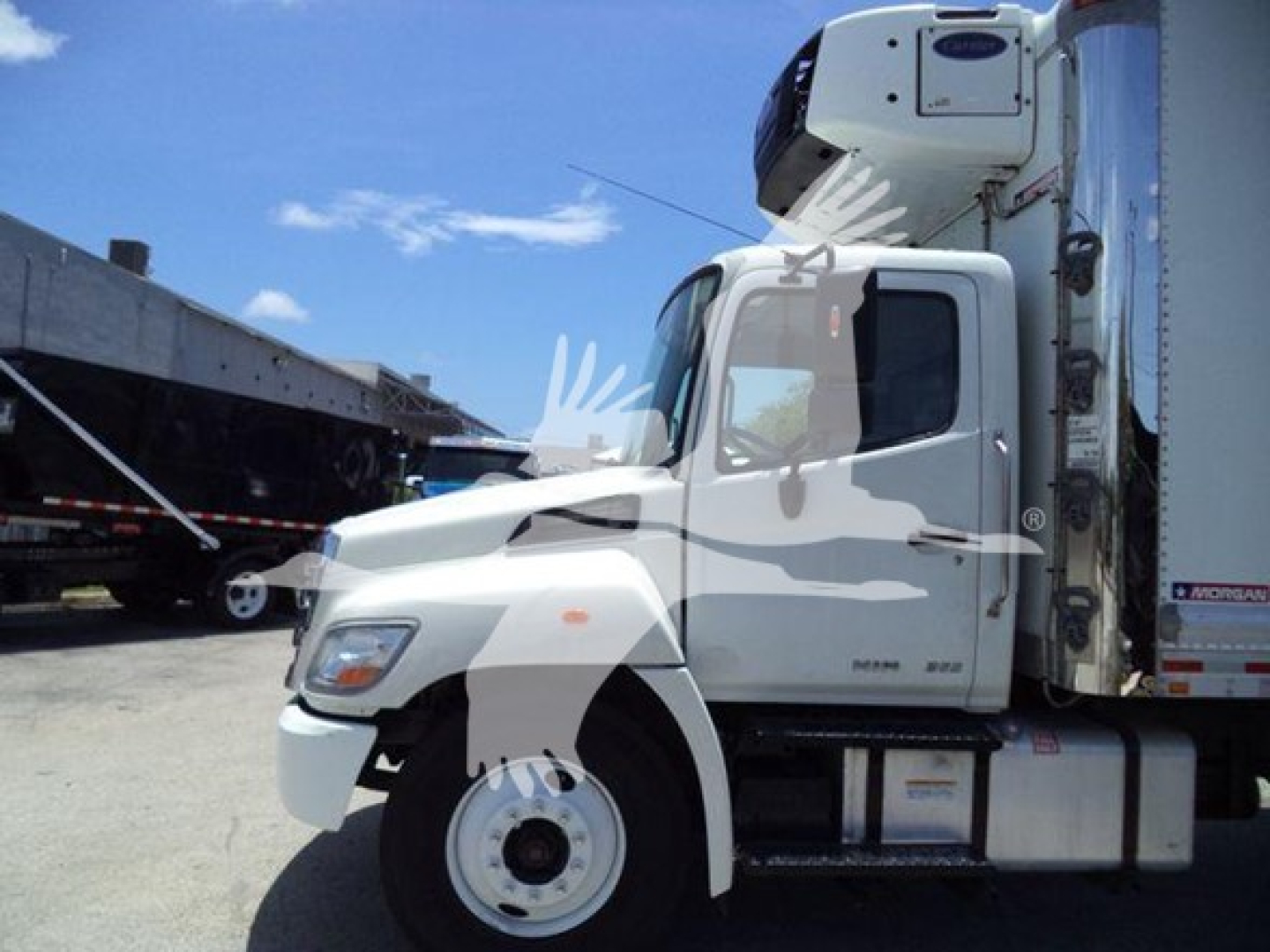 Truck cab side view showing 2019 Hino 268A refrigerated unit with raised sleeper, single axle, white cab.