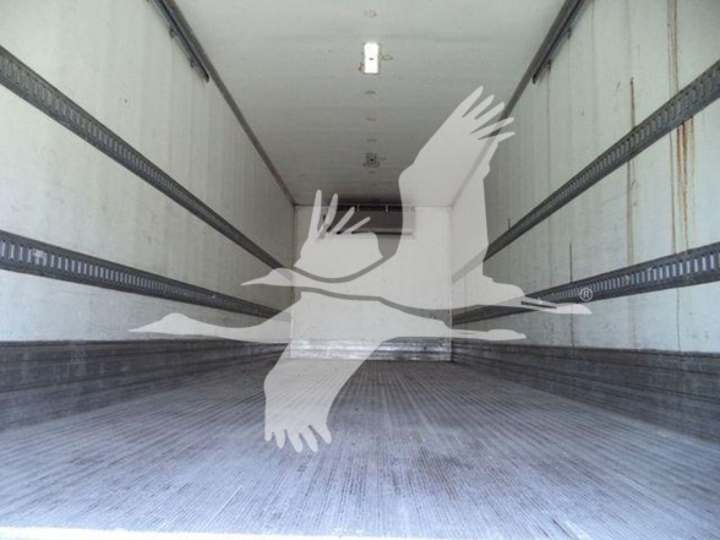 Trucking trailer interior (refrigerated) empty cargo area with aluminum floor and side rails, no visible cargo.