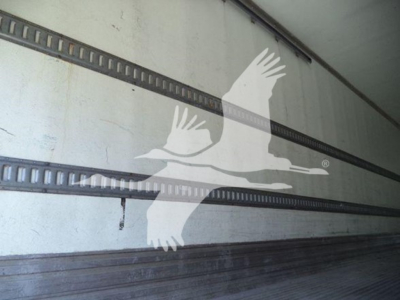Trailer interior with side rails and a translucent bird watermark; no readable text or labels visible.