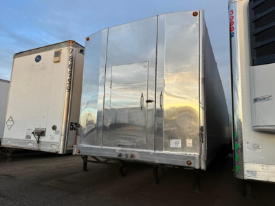 Trailer sides in a yard: 2023 Mac All Aluminum W Conestoga Sliding Tarp System with a polished aluminum rear doors and dual rear legs visible.