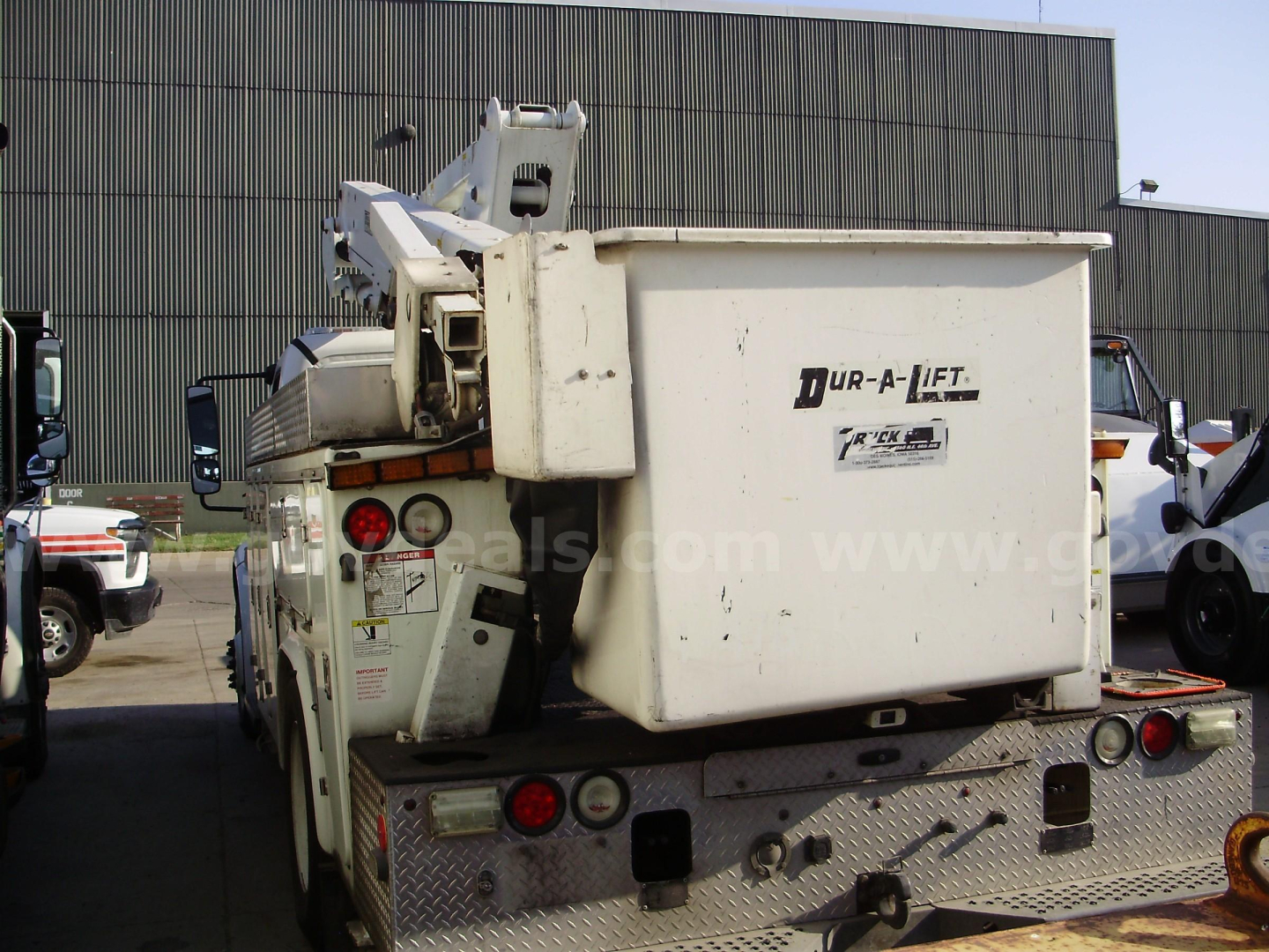 Freightliner M2 106 bucket truck rear view showing underbody diamond plate and cargo bucket with 'UR-A-LIFT' label.