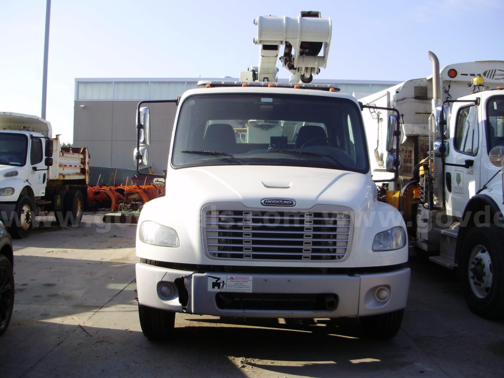 Freightliner M2 106 bucket truck front view showing grille, headlights, and boom lift on top.
