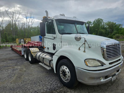 Freightliner Columbia 120 truck in light color shown from front-right angle with long chasis and flatbed trailer, VIN 1FUJA6CV33LL79728 visible in listing.