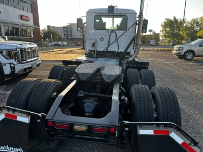 Truck chassis view showing rear dual rear axles, fifth wheel area, and back of cab. Visible are dual rear tires on both sides, frame rails, fifth wheel mounting, and rear lights.