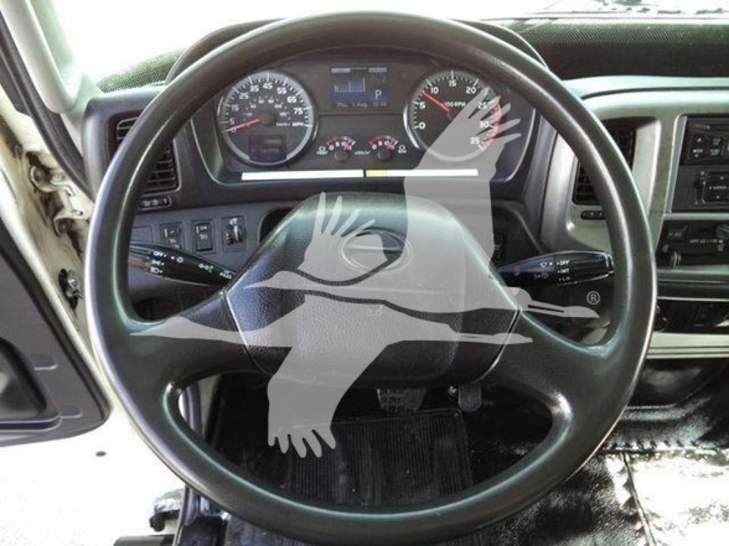 Truck cockpit with steering wheel and dashboard gauges visible.