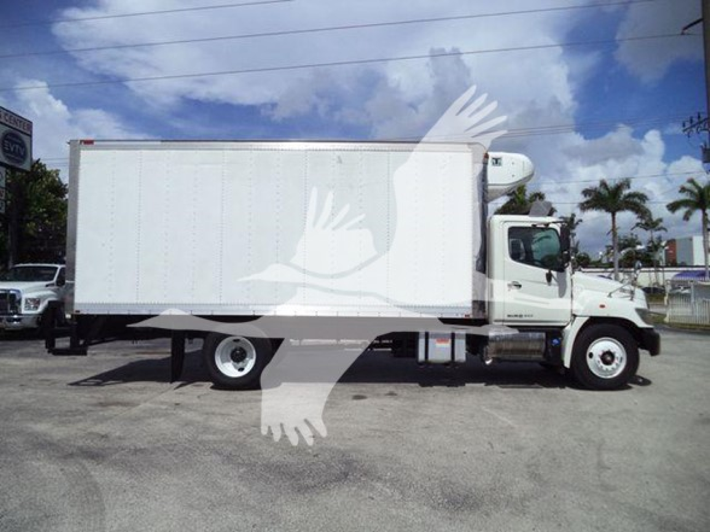 Truck side view of 2015 Hino 268A refrigerated box truck.