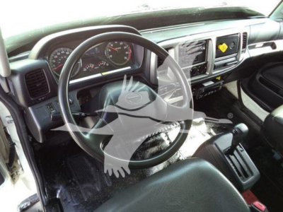 Dashboard and steering wheel of a 2015 Hino 268A truck cab interior showing steering wheel, instrument cluster, center console, and gear selector.